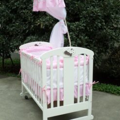 Lit en bois à barreaux pour bébé rose