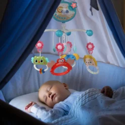 bébé dort dans son lit mobile musical vert